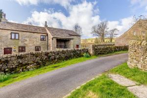 an old stone house with a stone wall next to a road at 2 Bed in Clitheroe oc-la156 in Harrop Fold