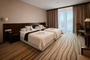 a hotel room with two beds and a large window at Budowlani Wellness & Medi Kompleks in Szczawnica +56 photos