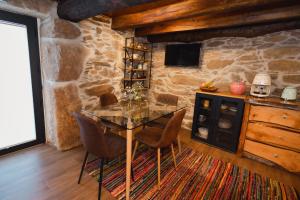 a dining room with a table and chairs and a stone wall at Casa do Cancelo in Mondim de Basto