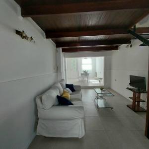 a living room with a white couch and a piano at La Ñata Apart in Junín