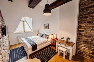 a bedroom with a bed and a desk and a window at Pension Zwicker in Prešov