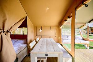 a tent with a table and a bed in it at Glamping Kamperland in Kamperland +59 photos