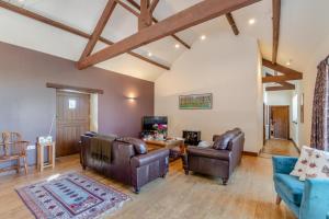 a living room with leather chairs and a tv at 3 Bed in Thwing oc-t29011 in Thwing