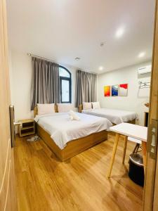 a hotel room with two beds and a table at Thanh hoa HOMESTAY in Hòa Bình