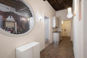 a hallway with a round mirror and a kitchen at 19 Steps Trevi in Rome