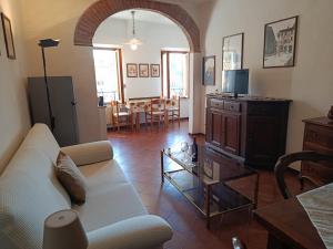 a living room with a white couch and a tv at Casa dell' Onda 25 in Siena