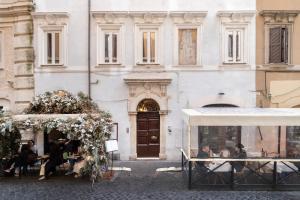 a group of people sitting at tables in front of a building at 19 Steps Trevi in Rome