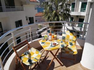 a balcony with a table and chairs on a balcony at Risinium sun in Risan +2 photos