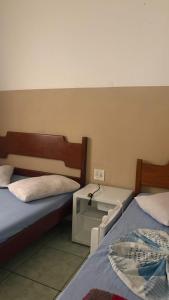 a room with two beds and a sink in it at HOTELSÃORAFAEl in Água Boa