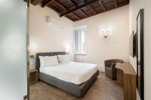 a hotel room with a bed and a chair at 19 Steps Trevi in Rome
