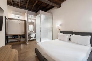 a bedroom with a large white bed and a mirror at 19 Steps Trevi in Rome
