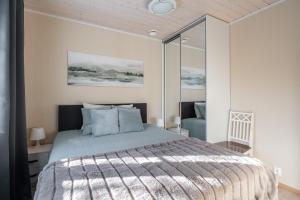 a bedroom with a large bed and a chair at Villa Magnolia 2 Himos in Jämsä