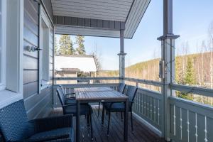 a porch with a table and chairs on it at Villa Magnolia 2 Himos in Jämsä