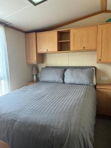 a bedroom with a large bed with wooden cabinets at The Mosselle No 60 in Ardentinny