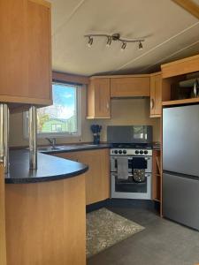 a kitchen with wooden cabinets and a white refrigerator at The Mosselle No 60 in Ardentinny