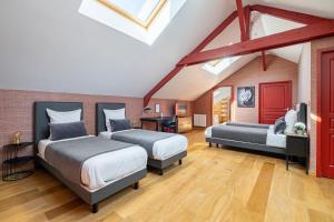a attic bedroom with two beds and a desk at Cosy Loft in Nantes in Nantes