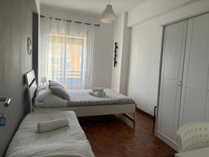 a bedroom with two beds and a window at Vieira's House in Barreiro