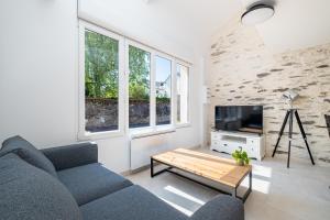 a living room with a blue couch and a tv at Cosy Loft in Nantes in Nantes