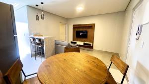 a living room with a wooden table and a kitchen at Essenza Living in Formosa