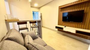 a living room with a couch and a flat screen tv at Essenza Living in Formosa +27 photos