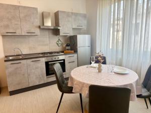 a kitchen with a table and chairs and a kitchen with a refrigerator at Loft moderno nel cuore del Centro Storico - spazioso & luminoso WiFi veloce- Tutto a piedi in Pordenone