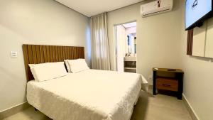 a hotel room with a bed and a television at Essenza Living in Formosa