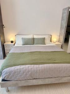 a large bed in a bedroom with two lamps at Loft moderno nel cuore del Centro Storico - spazioso & luminoso WiFi veloce- Tutto a piedi in Pordenone