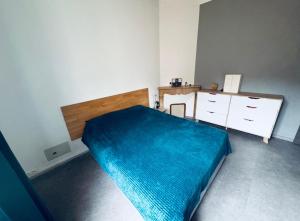 a bedroom with a blue bed and a dresser at 3 pièces TERRASSE et JACUZZI in Nîmes