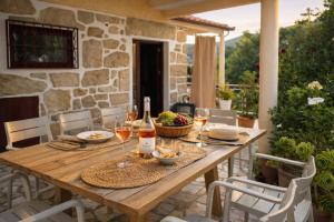 a wooden table with glasses of wine on a patio at Villa Esteves avec piscine proche Braga Parking-terrasse & calme in Vila Verde