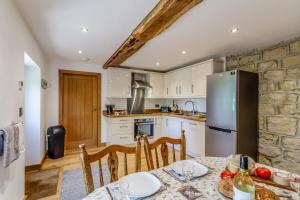 a kitchen with a table and a stainless steel refrigerator at 2 Bed in Pickering oc-t29975 in Middleton