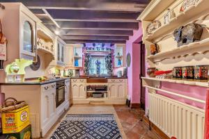 a large kitchen with white cabinets and purple walls at 1 Bed in Long Bennington oc-t29871 in Long Bennington