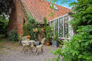 a garden with a table and chairs and a greenhouse at 1 Bed in Long Bennington oc-t29871 in Long Bennington