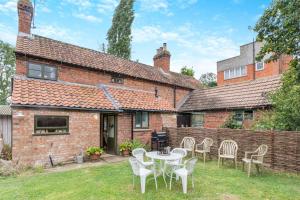 an exterior view of a brick house with a table and chairs at 4 Bed in Long Bennington oc-p29872 in Long Bennington