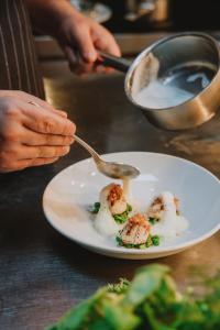 a person eating a plate of food with a spoon at The Black Horse in Amberley +63 photos