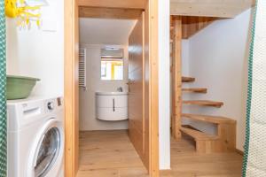 a tiny house with a staircase and a washing machine at The Little Cottage in Alleghe