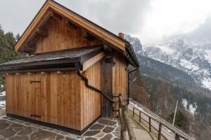 a small wooden building with a mountain in the background at The Little Cottage in Alleghe