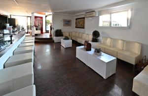 a large living room with white couches and tables at Hotel Biagini in Rimini