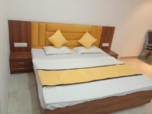 a bedroom with a large bed with a wooden headboard at Hotel Vijay Palace in Agra