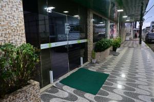 a green mat on a sidewalk in front of a building at Frota Palace Hotel in Macapá +43 photos
