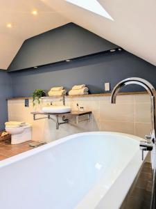a bathroom with a bath tub and a sink at Coastal Whisper Sleeps 10 with Parking in Reighton