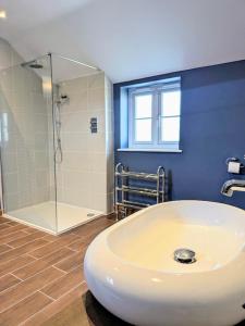 a bathroom with a shower and a white sink at Coastal Whisper Sleeps 10 with Parking in Reighton
