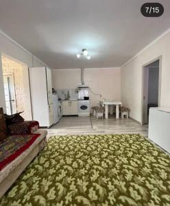 a large living room with a couch and a table at Коттедж in Cholpon-Ata +5 photos