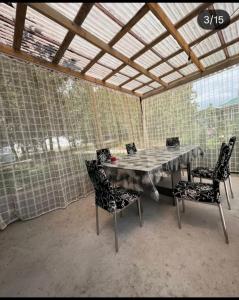 a dining room with a table and chairs in a room with mesh walls at Коттедж in Cholpon-Ata