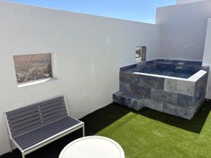 a room with a tub with a bench and a window at La Casita de Kai in El Médano
