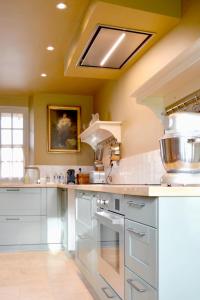 a large kitchen with white cabinets and a skylight at La Roseraie in Barjouville