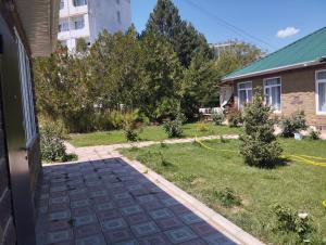 a driveway leading to a yard with trees at Коттедж in Cholpon-Ata