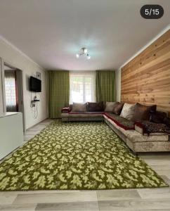 a living room with a couch and a green rug at Коттедж in Cholpon-Ata