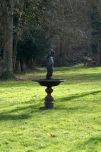 a statue of a bear sitting on top of a fountain in a field at La Roseraie in Barjouville