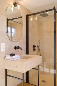 a bathroom with a sink and a shower with a mirror at La Roseraie in Barjouville +26 photos