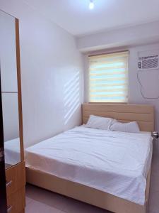 a bedroom with a white bed with a window at Vernes Homestay in Mandaue City